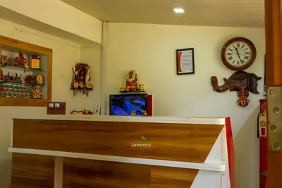a reception desk with a clock on the wall at D signature Homestay By Lexstays in Kushālnagar