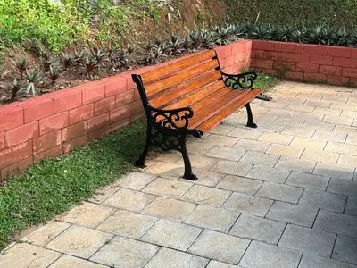 a wooden bench sitting next to a brick wall at Silver Oak By Exuberance Stays (Independent Holiday Home) in Wayanad