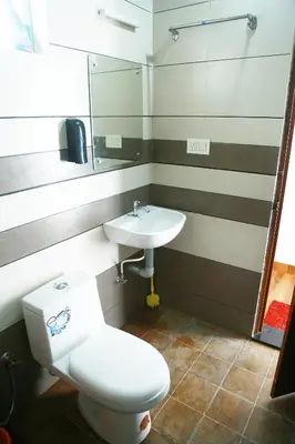 a bathroom with a toilet and a sink at Silver Oak By Exuberance Stays (Independent Holiday Home) in Wayanad