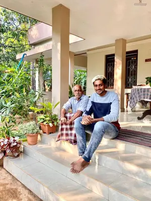two men sitting on the steps of a house at NARAYANALAYAM-Vintage Retreat-Homestay & Rest'Inn in Kannur