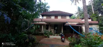 a house with a motorcycle parked in front of it at NARAYANALAYAM-Vintage Retreat-Homestay & Rest'Inn in Kannur