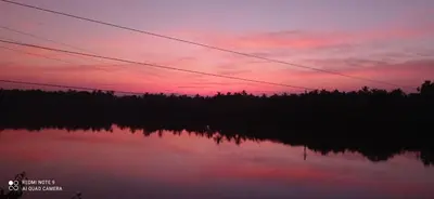 a sunset over a body of water with power lines at NARAYANALAYAM-Vintage Retreat-Homestay & Rest'Inn in Kannur