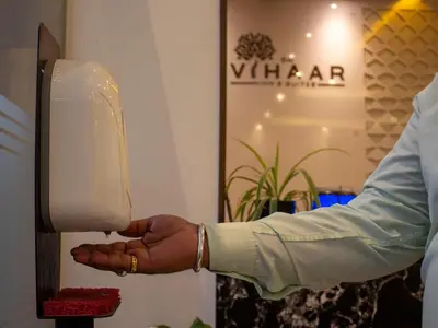 a person is holding a soap dispenser at Sai Vihaar Inn & Suites in Mysore