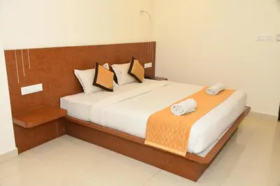 a bedroom with a bed with two towels on it at Sai Vihaar Inn & Suites in Mysore