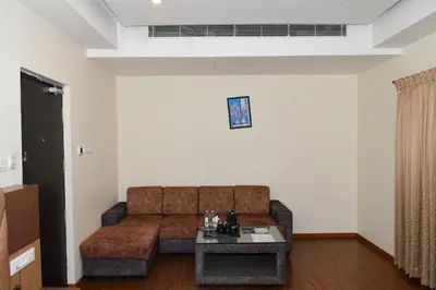 a living room with a couch and a table at Sai Vihaar Inn & Suites in Mysore