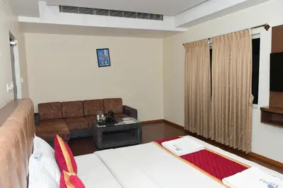a living room with two beds and a couch at Sai Vihaar Inn & Suites in Mysore