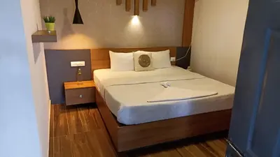 a small bedroom with a bed with white sheets at Wild root stay- Aster Chalet in Wayanad