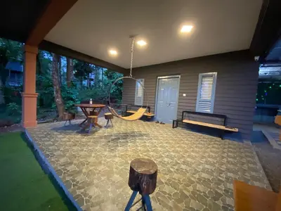 a patio with a playground with a swing at Wild root stay- Aster Chalet in Wayanad