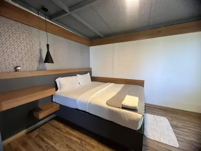 a bedroom with a large bed with a wooden headboard at Wild root stay- Aster Chalet in Wayanad