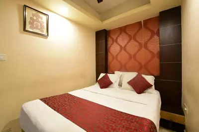 a hotel room with a bed with red pillows at Shastri Paradise opst to KSRTC Bus Stand in Mysore