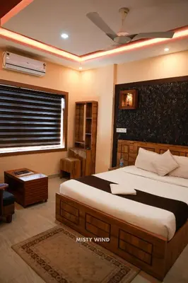 a bedroom with a large bed and a window at Vythiri Misty Wind Holiday Homes in Vythiri