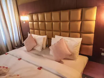 a bedroom with a large bed with a padded headboard at The Wave Lakeview Resort & Spa in Wayanad