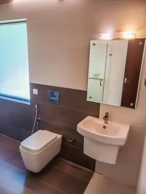 a bathroom with a white toilet and a sink at The Wave Lakeview Resort & Spa in Wayanad
