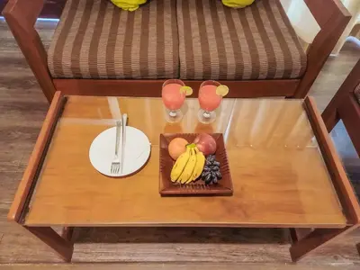 a table with a plate of fruit and a plate of food at The Wave Lakeview Resort & Spa in Wayanad