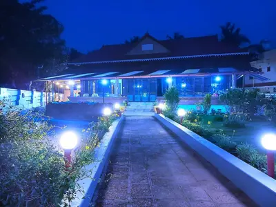 a house with lights in front of it at night at Beach Nest in Kannur
