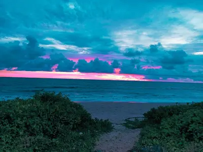a sunset over the ocean with a pink horizon at Beach Nest in Kannur