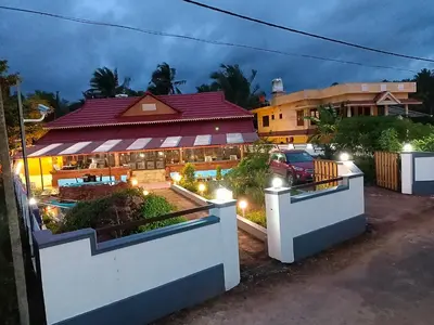 a house with a car parked in front of it at Beach Nest in Kannur