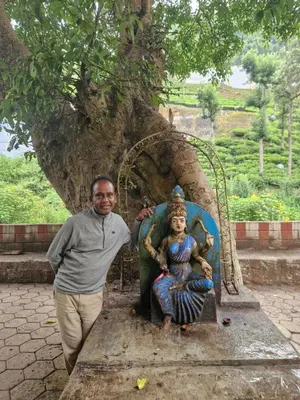 a man standing next to a statue of a woman at Narmada Holiday Home in Ooty