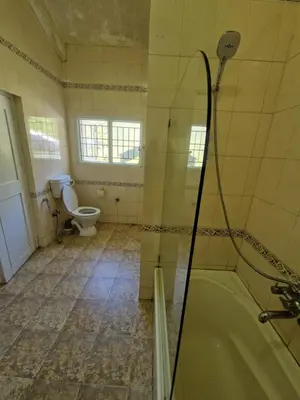 a bathroom with a tub and a toilet at Narmada Holiday Home in Ooty