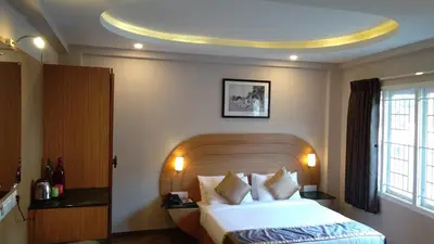 a hotel room with a large bed and a large window at Mango Hill Central Ooty in Ooty