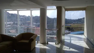 a living room with a view of a large window at Mango Hill Central Ooty in Ooty