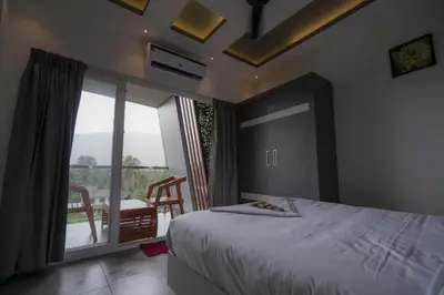 a bedroom with a bed and a large window with a view at BBC Luxury Apartments in Perintalmanna