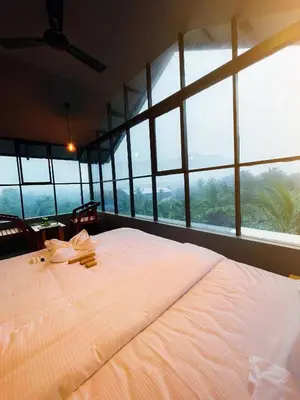 a large bed in a room with large windows at BBC Luxury Apartments in Perintalmanna