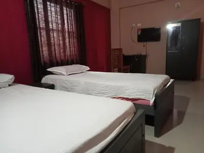 two beds in a room with red walls at SAFA RESIDENCY in Perintalmanna