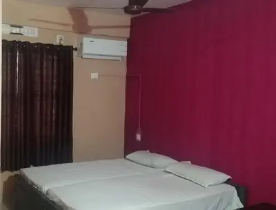 a bedroom with two beds and a purple wall at SAFA RESIDENCY in Perintalmanna