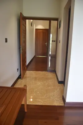 an empty hallway with a door and a wooden floor at Jeevess Retreat Wayanad in Wayanad