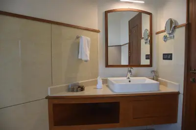 a bathroom with a sink and a mirror and a shower at Jeevess Retreat Wayanad in Wayanad