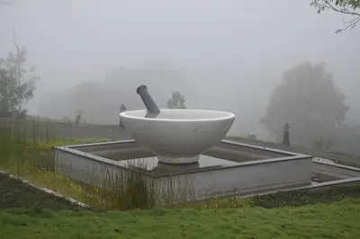 a large white bowl with a pipe sitting in the grass at Jeevess Retreat Wayanad in Wayanad