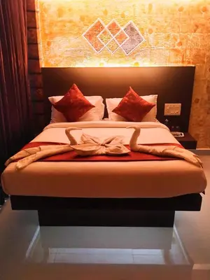 a bedroom with a bed with red pillows at Rambler Garden Resort in Idukki
