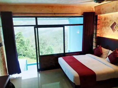a bedroom with a bed and a large window at Rambler Garden Resort in Idukki