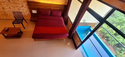 a room with a couch and a chair and a window at Rambler Garden Resort in Idukki
