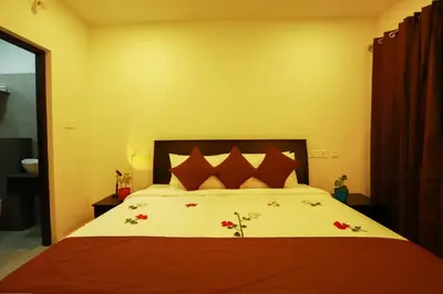 a bedroom with a large bed with red pillows at SATRA WAYANAD in Kalpetta