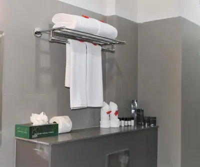 a bathroom with white towels on a shelf at SATRA WAYANAD in Kalpetta