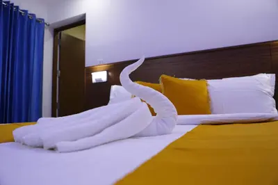 a bed with a white towel shaped like a swan on it at AP Residency in Wayanad