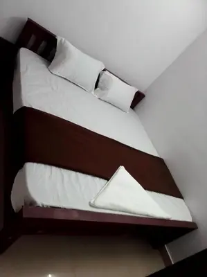 two beds in a room with white sheets and pillows at Emirates Residency in Pudunagaram