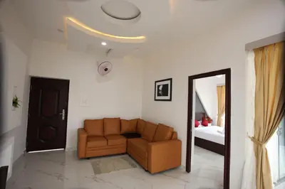 a living room with a couch and a bed at Emirates Residency in Pudunagaram