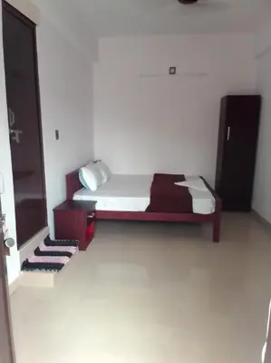 a bedroom with a bed in a room at Emirates Residency in Pudunagaram