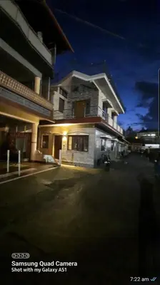 a large white building with a lit up corner at Varam Homestay in Madikeri
