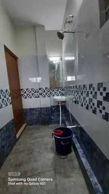a bathroom with a sink and a bucket at Varam Homestay in Madikeri