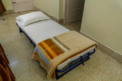 a small bed with a blanket on it in a room at Belljem Homes -your own private resort -1 BR in Trichūr