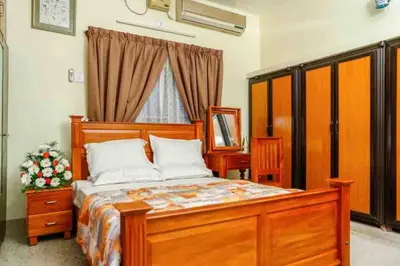 a bedroom with a wooden bed and a window at Belljem Homes -your own private resort -6 BHK B in Trichūr
