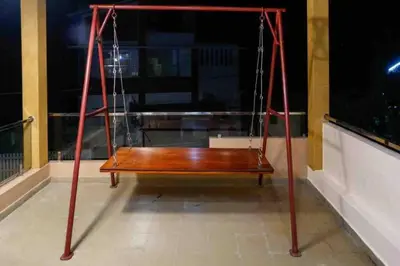 a swing on top of a balcony at night at Belljem Homes -your own private resort -6 BHK B in Trichūr