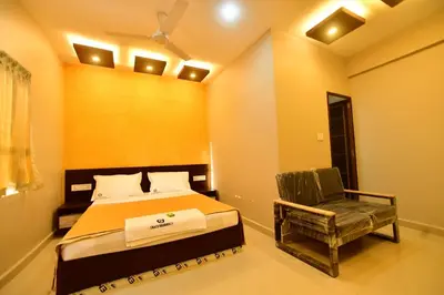 a bedroom with a bed and a chair at GRACE RESIDENCY in Tirūr