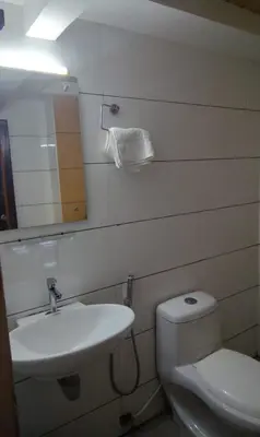 a bathroom with a toilet and a sink and a mirror at GRACE RESIDENCY in Tirūr