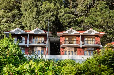 a red brick building with balconies and trees at Vista Suites Doddabetta Ooty By Bestinn Leisure in Ooty