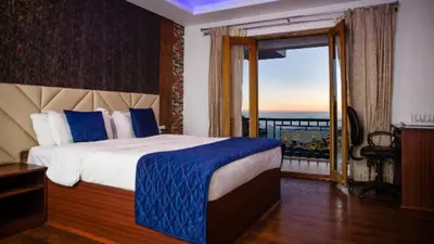 a bedroom with a bed with a view of the ocean at Vista Suites Doddabetta Ooty By Bestinn Leisure in Ooty